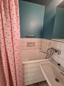 un baño con bañera y lavabo en Kerrostalokaksio, en Pori