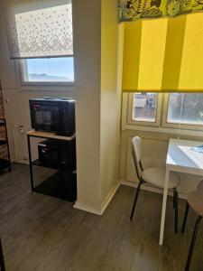 Habitación con mesa, TV y silla. en Kerrostalokaksio, en Pori