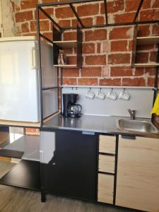 cocina con fregadero y pared de ladrillo en Kerrostalokaksio, en Pori