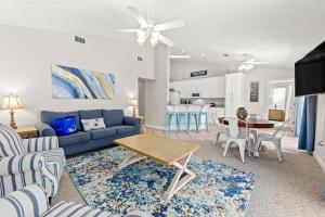 a living room with a blue couch and a table at Great Rates Available NOW! / Relaxing Coastal Beach Home West PCB / 3Bd & 2Ba in Sunnyside