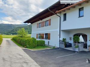 a white house with a parking lot in front of it at Apartment am Wolfgangsee in Strobl