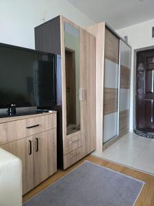 a living room with a large flat screen tv at Orchid Fort Garden in Sunny Beach +8 photos