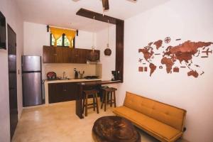 a kitchen with a couch and a kitchen with a world map on the wall at La HouseFina ground floor 1 in Holbox Island