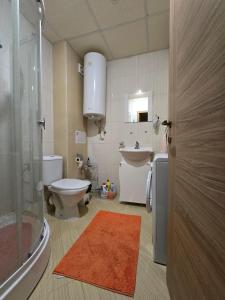 a bathroom with a toilet and a sink and a mirror at Orchid Fort Garden in Sunny Beach