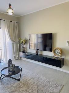 een woonkamer met een grote flatscreen-tv bij LLL Apartments M6 in Khakalashwe
