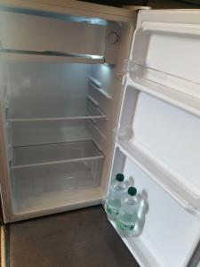 an open refrigerator with two bottles of water in it at studio Nancy 122 in Nancy