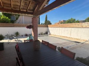un patio con piscina e terrazza in legno di Maison 3 chambres de Sandrine et Julien a Saint-Privat-des-Vieux Altre 2 foto
