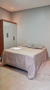 a bedroom with a large bed and a cabinet at Experiência Gourmet em MOC in Montes Claros