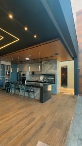 a large kitchen and dining room with a hard wood floor at Experiência Gourmet em MOC in Montes Claros