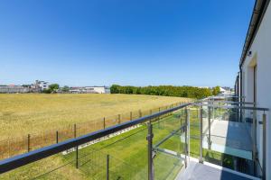 a balcony with a view of a field at Dorsza Green View Pogórze by Solarento in Pogórze