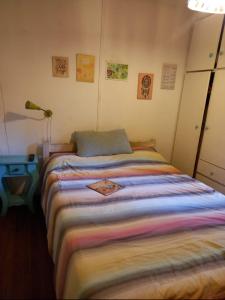 a bedroom with a bed with a colorful blanket at El Domo y La Petaca Delta del Tigre in Tigre