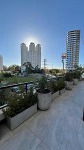 a row of potted plants on a balcony with buildings at Brickell Aiby in Tigre