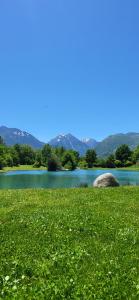 a green field with a lake and mountains in the background at 4 personnes au pied des piste et sentier de randonné in Saint-Lary-Soulan