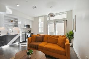un salon avec un canapé orange et une cuisine dans l'établissement Urban Elegance | Espadin LoHi, à Denver