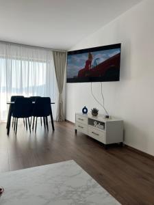 a living room with a table and a tv on the wall at B&B ApartHotel in Bistriţa