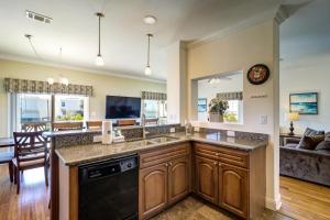 a kitchen with a sink and a living room at Summer Dayz - Families Love It Here, Just Across from the Beach in Panama City Beach
