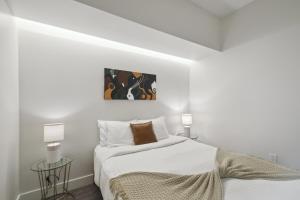 a white bedroom with a bed and two lamps at Southwestern Charm | Espadin LoHi in Denver