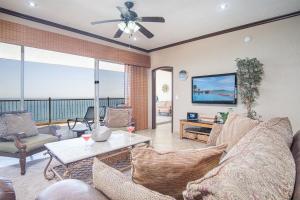 a living room with a couch and a ceiling fan at Sonoran Sky in Puerto Peñasco