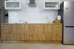 a kitchen with wooden cabinets and a refrigerator at Apartment In the Heart of Warsaw in Warsaw