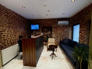 ein Wohnzimmer mit einer Couch und einer Ziegelwand in der Unterkunft Galata Calm Tale Hotel in Istanbul