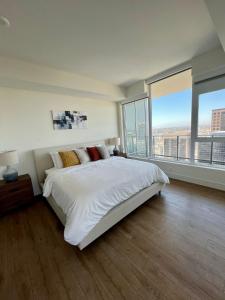 a white bedroom with a large bed and large windows at The Daisy-Highrise 2BR Marina View,Pool,Jacuzzi,Gym&Parking in San Diego