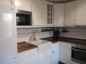 a white kitchen with a sink and a microwave at Family Vacation in Málaga