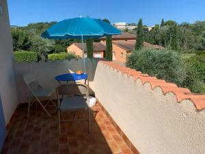 a table and two chairs and an umbrella on a patio at Chambre douillette avec balcon a 7min de Vaison la Romaine in Saint-Romain-en-Viennois +17 photos