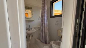a bathroom with a sink and a shower curtain at Ionian Sunset in Lefkada