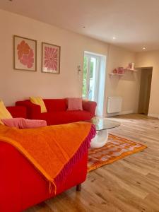 a living room with a red couch and a glass table at Maison avec terrasse et jardin in Avallon