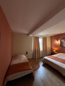 a hotel room with two beds and a window at Maison avec terrasse et jardin in Avallon