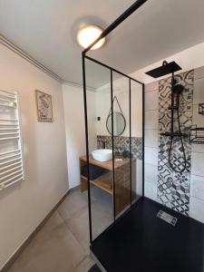 a bathroom with a glass shower with a sink at Maison avec terrasse et jardin in Avallon