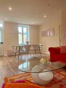 a living room with a table and a red couch at Maison avec terrasse et jardin in Avallon