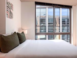 a bedroom with a large white bed and a large window at City & River View Suite - The Wharf DC by Monthier in Washington