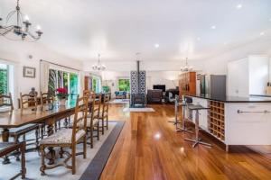 a kitchen and living room with a table and chairs at NZ County Holiday Home in Kamo