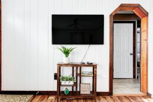 a living room with a television on a white wall at Lake Huron Getaway by arc Vacation Rentals in Lexington
