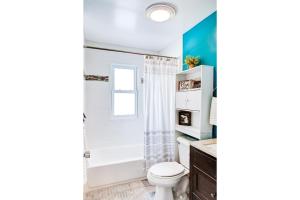 a bathroom with a white toilet and a shower at Lake Huron Getaway by arc Vacation Rentals in Lexington