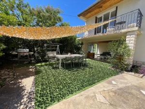 a backyard with a table and chairs and a tableablish at Maison calme, piscine et festival à deux pas in Villeneuve-lès-Avignon