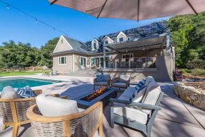 a patio with chairs and a fire pit in front of a house at Sycamore Ranch in Templeton