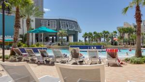 - un groupe de chaises et une piscine bordée de palmiers dans l'établissement Gorgeous 1-Bed 2-Bath condo with Gulf View! Pools On-Site! Walk To The Beach!, à Panama City Beach
