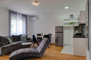 a living room with a couch and a kitchen at Lemona Apartmani Vrnjačka Banja in Vrnjci