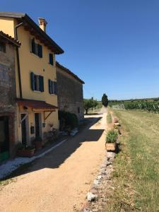 a dirt road next to a house in a field at La Grotta in Pastrengo