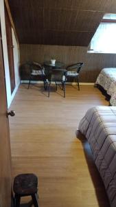 a room with a bed and a table and chairs at Habitaciones Alpinas Oxapampa in San Antonio