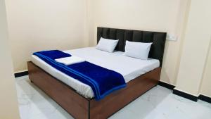 Una cama con una manta azul encima. en shree angareshwar home stay, en Makoria Ām