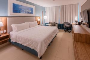 a hotel room with a large bed and a desk at Holiday Inn Acapulco La Isla by IHG in Acapulco