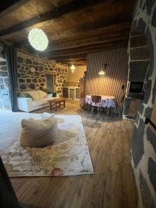 a living room with a bed and a stone wall at La maison des petites choses, la tiny house du Puy Mary-Cantal in Lascelle +16 photos