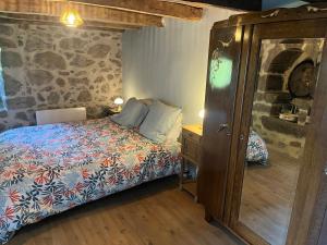 a bedroom with a bed and a dresser in a room at La maison des petites choses, la tiny house du Puy Mary-Cantal in Lascelle