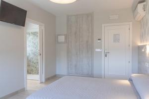 a white bedroom with a bed and a sliding door at Hotel Leal - La Sirena in Villanueva de Arosa