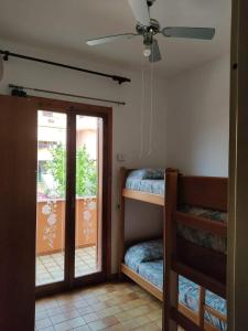 Habitación con 2 literas y puerta corredera de cristal. en Villa Rosalba, en Villasimius