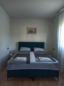 een slaapkamer met een bed met twee kussens bij Estrella Apartment Mostar in Mostar