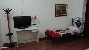 a room with a tv and a bed and a desk at Casa vacanze di Emilia e Vincenzo in Roggiano Gravina